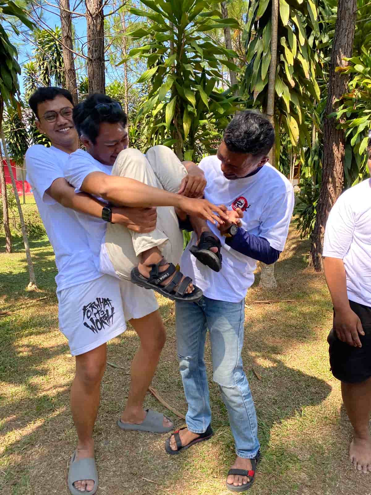 Anggota tim berpartisipasi dalam permainan kerja sama di lapangan Guci